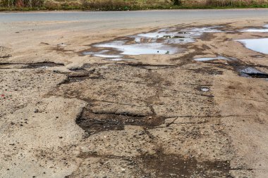 Çok kötü asfalt yol. Asfalttaki çatlaklar, çukurlar. Düşük kalitede bir yamadan sonra yerel asfalt yolunun durumu çok kötü