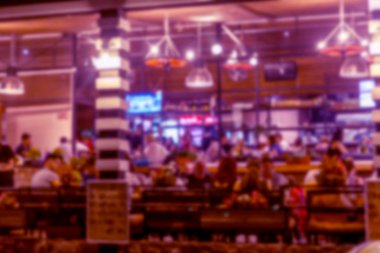 Küçük bir restoranın içi bulanık bir arka plan. Bokeh Kafe 'nin içini sıcak koyu renklerle bulanıklaştırmış. Yaratıcı moda tasarımı için arka plan olarak. Restoran, kafeterya arka planı çok güzel bulanık.