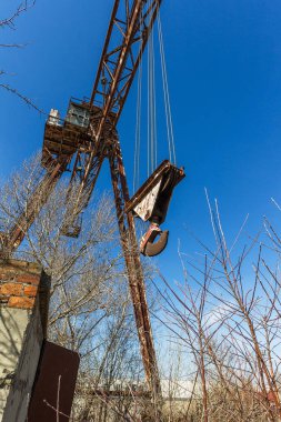 Eski paslı terk edilmiş binada portal vinç paslı raylar üzerinde. Terk edilmiş konteyner yükleme boşaltma inşaat ambar. Ölü Zona. Mezarlık Çernobil, Pripyat, Ukrayna mühendislik; Bölge nükleer felaket