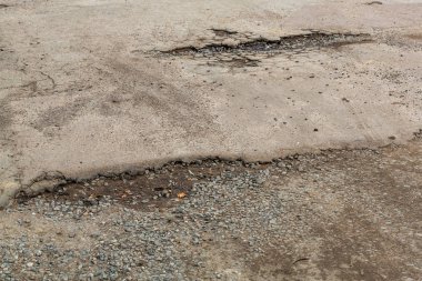 Çok kötü asfalt yol. Asfalttaki çatlaklar, çukurlar. Düşük kalitede bir yamadan sonra yerel asfalt yolunun durumu çok kötü