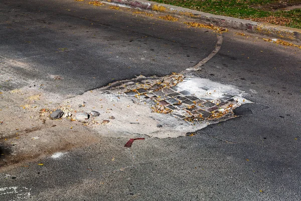 Very bad paved road. Cracks in the pavement, potholes. Very poor condition of local asphalt road after a low-quality patching