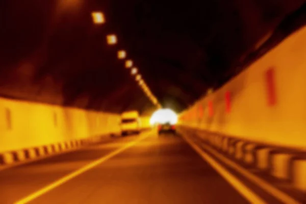 Abstract Motion Blur Background road tunnel with moving cars and light at the end. For use as a creative design blank. Light line of traffic in the tunnel lighting car highway