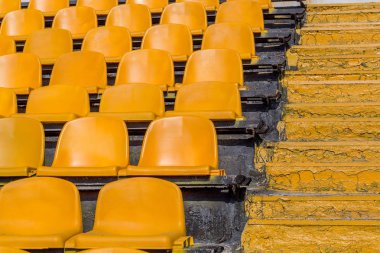 Stadyumun boş eski plastik sandalyeler. Küçük bir eski stadyumda boş koltuk sayısı. Hayranları için çizilmiş yıpranmış plastik koltuk