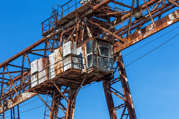 Old rusty abandoned building gantry crane on rusty rails. Abandoned container loading unloading construction warehouse. Dead Zona. Cemetery of engineering Chernobyl, Pripyat, Ukraine; Zone nuclear catastrophe