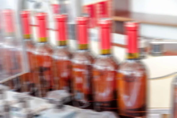 Production of industrial conveyor belt in the winery with glass bottles in the process of work and movement. Motion blur. Not without a sharp focus background for an industrial design