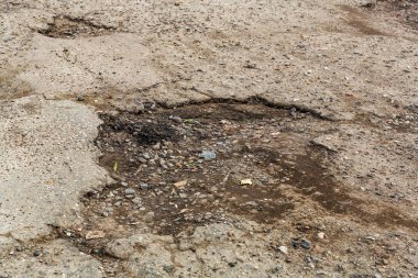 Çok kötü asfalt yol. Asfalttaki çatlaklar, çukurlar. Düşük kalitede bir yamadan sonra yerel asfalt yolunun durumu çok kötü