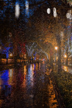 Gece cityscape bulanıklık. Gece yağmur sonra şehir antik ortasına. Gece kentsel sokak sokak kafeleri ve hareketli araba parlak renkli ışıkları ile. Hareket bulanıklığı, yumuşak odak, minimalist