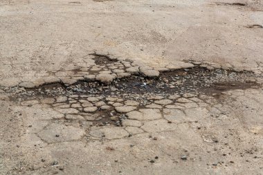 Çok kötü asfalt yol. Asfalttaki çatlaklar, çukurlar. Düşük kalitede bir yamadan sonra yerel asfalt yolunun durumu çok kötü