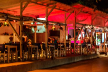 Küçük bir restoranın içi bulanık bir arka plan. Bokeh Kafe 'nin içini sıcak koyu renklerle bulanıklaştırmış. Yaratıcı moda tasarımı için arka plan olarak. Restoran, kafeterya arka planı çok güzel bulanık.