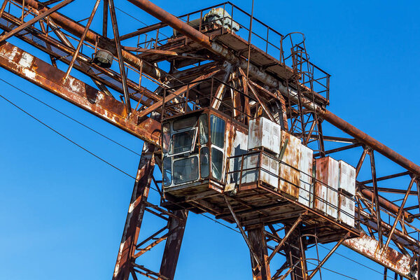 Old rusty abandoned building gantry crane on rusty rails. Abandoned container loading unloading construction warehouse. Dead Zona. Cemetery of engineering Chernobyl, Pripyat, Ukraine; Zone nuclear catastrophe