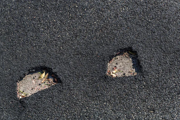 Very bad paved road. Cracks in the pavement, potholes. Very poor condition of local asphalt road after a low-quality patching