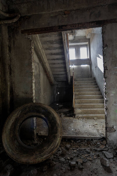Interior of an abandoned administrative building. Interior ruins of an industrial factory. An old concrete staircase, ruins, corridor with garbage and mud, ruined walls of an unfinished office business center, Odessa