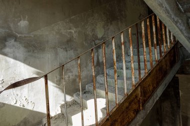 Old destroyed concrete, stone staircase in interior of ruins of unfinished administrative building of business center. Ruined old staircase in interior of abandoned factory building clipart