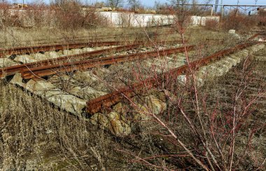 Demiryolu, kırık raylar, kırık tahta uyuyanlar terk edilmiş. Demiryolu kırık kalıntıları. Yağmaladılar eski demiryolu. Yol alabileceği bir yol vardır. Enkaz, kalıntıları, eski tuval unsurları. Seçici odak