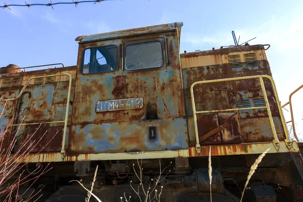 Old rusty train locomotive thrown into exclusion zone of Chernobyl. Zone of high radioactivity. Ghost town of Pripyat. Chernobyl disaster. Rusty abandoned Soviet machinery in area of nuclear accident at plant