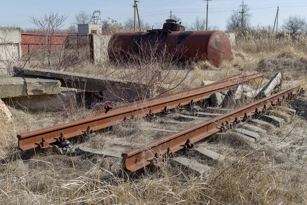 Old abandoned railway, broken rails, broken wooden sleepers. Broken remains of railway. Plundered old railway. There is no road. Debris, remnants, elements of old canvas. Selective focus