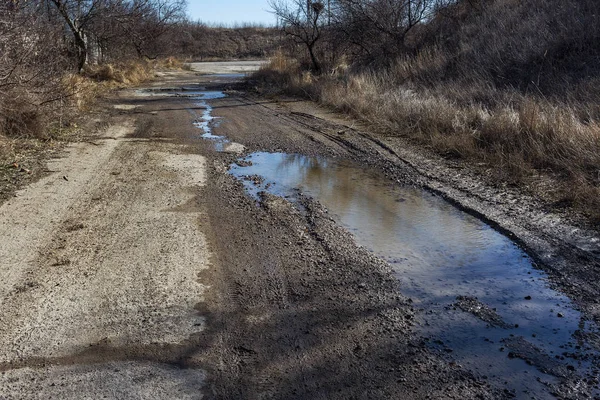 Very bad paved road. Cracks in the pavement, potholes. Very poor condition of local asphalt road after a low-quality patching