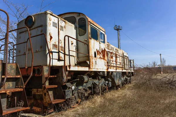 Old rusty train locomotive thrown into exclusion zone of Chernobyl. Zone of high radioactivity. Ghost town of Pripyat. Chernobyl disaster. Rusty abandoned Soviet machinery in area of nuclear accident at plant