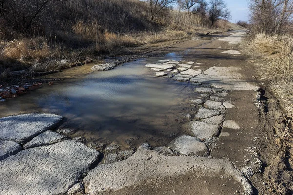 Very bad paved road. Cracks in the pavement, potholes. Very poor condition of local asphalt road after a low-quality patching