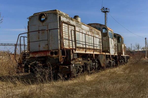 Old rusty train locomotive thrown into exclusion zone of Chernobyl. Zone of high radioactivity. Ghost town of Pripyat. Chernobyl disaster. Rusty abandoned Soviet machinery in area of nuclear accident at plant