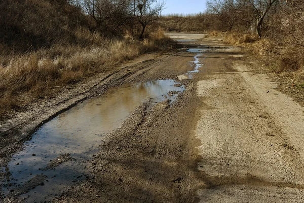 Very bad paved road. Cracks in the pavement, potholes. Very poor condition of local asphalt road after a low-quality patching