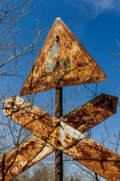 風化オールドさびた看板鉄道踏切に傷 古い道路標識危険は停止 踏切前に鉄道を渡します 旧道路とレールの敷地の古い放棄された道路標識 — ストック写真