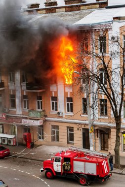 Odessa, Ukrayna - 29 Aralık 2016: Bir binanın içinde bir ateş. Güçlü parlak ışık ve kulüpleri, duman bulutları pencere yanan ağırlıyorlar. İtfaiyeciler evde yangın söndürmek. Yangın merdivenleri üzerinde çalışmak