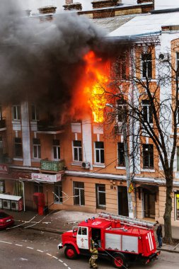 Odessa, Ukrayna - 29 Aralık 2016: Bir binanın içinde bir ateş. Güçlü parlak ışık ve kulüpleri, duman bulutları pencere yanan ağırlıyorlar. İtfaiyeciler evde yangın söndürmek. Yangın merdivenleri üzerinde çalışmak