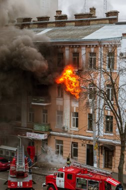 Odessa, Ukrayna - 29 Aralık 2016: Bir binanın içinde bir ateş. Güçlü parlak ışık ve kulüpleri, duman bulutları pencere yanan ağırlıyorlar. İtfaiyeciler evde yangın söndürmek. Yangın merdivenleri üzerinde çalışmak