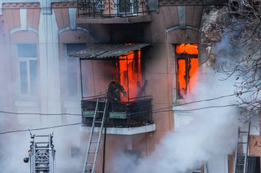  Bir yangında bir apartman. Güçlü parlak ışık ve kulüpleri, duman bulutları pencere yanan ağırlıyorlar. İtfaiyeciler evde yangın söndürmek. Yangın merdivenleri üzerinde çalışmak