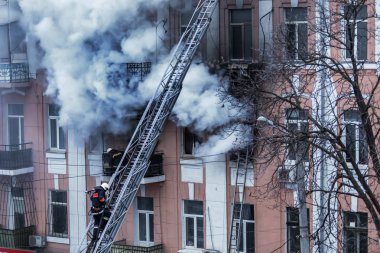 Odessa, Ukrayna - 29 Aralık 2016: Bir binanın içinde bir ateş. Güçlü parlak ışık ve kulüpleri, duman bulutları pencere yanan ağırlıyorlar. İtfaiyeciler evde yangın söndürmek. Yangın merdivenleri üzerinde çalışmak