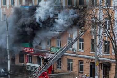 Odessa, Ukrayna - 29 Aralık 2016: Bir binanın içinde bir ateş. Güçlü parlak ışık ve kulüpleri, duman bulutları pencere yanan ağırlıyorlar. İtfaiyeciler evde yangın söndürmek. Yangın merdivenleri üzerinde çalışmak