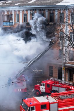 Odessa, Ukrayna - 29 Aralık 2016: Bir binanın içinde bir ateş. Güçlü parlak ışık ve kulüpleri, duman bulutları pencere yanan ağırlıyorlar. İtfaiyeciler evde yangın söndürmek. Yangın merdivenleri üzerinde çalışmak