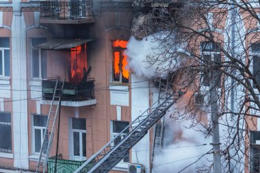 Odessa, Ukrayna - 29 Aralık 2016: Bir binanın içinde bir ateş. Güçlü parlak ışık ve kulüpleri, duman bulutları pencere yanan ağırlıyorlar. İtfaiyeciler evde yangın söndürmek. Yangın merdivenleri üzerinde çalışmak