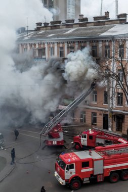 Odessa, Ukrayna - 29 Aralık 2016: Bir binanın içinde bir ateş. Güçlü parlak ışık ve kulüpleri, duman bulutları pencere yanan ağırlıyorlar. İtfaiyeciler evde yangın söndürmek. Yangın merdivenleri üzerinde çalışmak