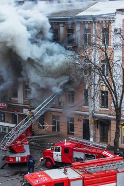 Odessa, Ukrayna - 29 Aralık 2016: Bir binanın içinde bir ateş. Güçlü parlak ışık ve kulüpleri, duman bulutları pencere yanan ağırlıyorlar. İtfaiyeciler evde yangın söndürmek. Yangın merdivenleri üzerinde çalışmak