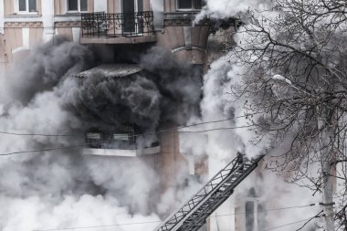 Odessa, Ukrayna - 29 Aralık 2016: Bir binanın içinde bir ateş. Güçlü parlak ışık ve kulüpleri, duman bulutları pencere yanan ağırlıyorlar. İtfaiyeciler evde yangın söndürmek. Yangın merdivenleri üzerinde çalışmak