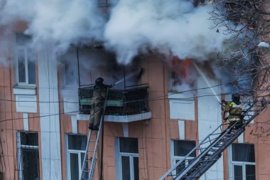 Odessa, Ukrayna - 29 Aralık 2016: Bir binanın içinde bir ateş. Güçlü parlak ışık ve kulüpleri, duman bulutları pencere yanan ağırlıyorlar. İtfaiyeciler evde yangın söndürmek. Yangın merdivenleri üzerinde çalışmak