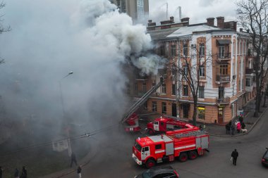Odessa, Ukrayna - 29 Aralık 2016: Bir binanın içinde bir ateş. Güçlü parlak ışık ve kulüpleri, duman bulutları pencere yanan ağırlıyorlar. İtfaiyeciler evde yangın söndürmek. Yangın merdivenleri üzerinde çalışmak