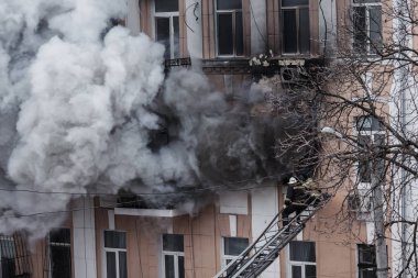 Odessa, Ukrayna - 29 Aralık 2016: Bir binanın içinde bir ateş. Güçlü parlak ışık ve kulüpleri, duman bulutları pencere yanan ağırlıyorlar. İtfaiyeciler evde yangın söndürmek. Yangın merdivenleri üzerinde çalışmak