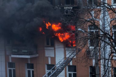 Odessa, Ukrayna - 29 Aralık 2016: Bir binanın içinde bir ateş. Güçlü parlak ışık ve kulüpleri, duman bulutları pencere yanan ağırlıyorlar. İtfaiyeciler evde yangın söndürmek. Yangın merdivenleri üzerinde çalışmak