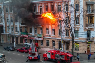 Odessa, Ukrayna - 29 Aralık 2016: Bir binanın içinde bir ateş. Güçlü parlak ışık ve kulüpleri, duman bulutları pencere yanan ağırlıyorlar. İtfaiyeciler evde yangın söndürmek. Yangın merdivenleri üzerinde çalışmak