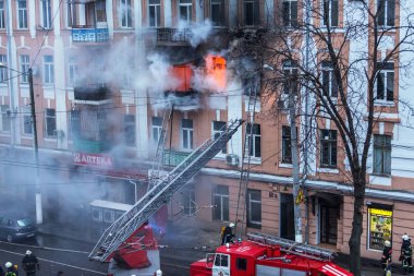 Odessa, Ukrayna - 29 Aralık 2016: Bir binanın içinde bir ateş. Güçlü parlak ışık ve kulüpleri, duman bulutları pencere yanan ağırlıyorlar. İtfaiyeciler evde yangın söndürmek. Yangın merdivenleri üzerinde çalışmak