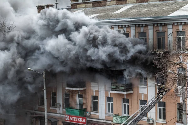 Odessa, Ukrayna - 29 Aralık 2016: Bir binanın içinde bir ateş. Güçlü parlak ışık ve kulüpleri, duman bulutları pencere yanan ağırlıyorlar. İtfaiyeciler evde yangın söndürmek. Yangın merdivenleri üzerinde çalışmak