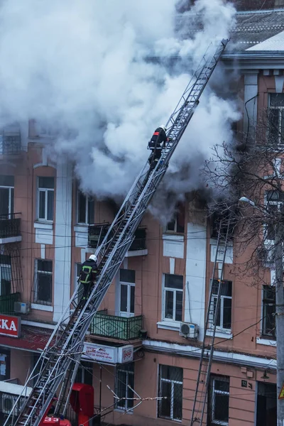 Odessa, Ukrayna - 29 Aralık 2016: Bir binanın içinde bir ateş. Güçlü parlak ışık ve kulüpleri, duman bulutları pencere yanan ağırlıyorlar. İtfaiyeciler evde yangın söndürmek. Yangın merdivenleri üzerinde çalışmak