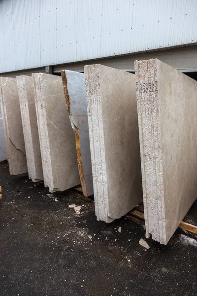 Side view of the edge of the granite slab in bulk. A stack of granite slabs - marble factory. Background of marble slabs. Natural stone. Background of granite slabs. Granite slabs ready for sale