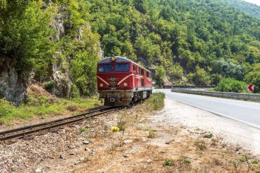 Bansko, Bulgaristan -29 Temmuz 2016: küçük retro rock Tren Garı yolcu sırt boyunca geçmiş dağ yolu virajlı yıpranmış eski dar hat raylar üzerinden taşır