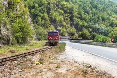 Bansko, Bulgaristan -29 Temmuz 2016: küçük retro rock Tren Garı yolcu sırt boyunca geçmiş dağ yolu virajlı yıpranmış eski dar hat raylar üzerinden taşır