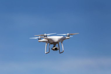 Profesyonel hava dron video kamera görüntüleri yukarıdan vuruyor. Büyük beyaz helikopter Uçak yüksekten mavi gökyüzünde uçuyor. Casus helikopter havada sinek kablosuz uzaktan kumanda ile