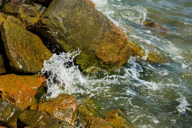 Granit taş kõyõ alanlarõ ve akış aşağı kum Beach sakin mola sırasında yumuşak küçük dalgalar. Dalga deniz köpük buzlu karşı bozuldu. Dalga düşme ve çöl beac kıyısında boyunca akar